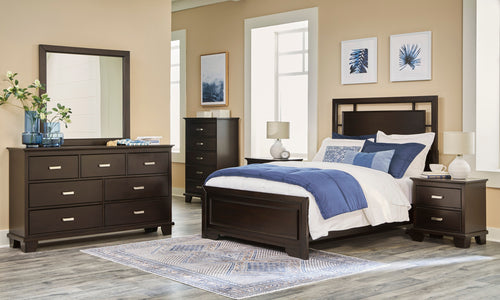 Dormitorio con muebles de madera oscura, que incluye cama, gavetero con espejo y mesitas de noche, con ropa de cama azul y blanca.