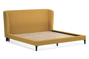 Cama tapizada en color amarillo mostaza sobre fondo blanco.
