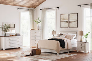 Dormitorio ordenado con muebles y decoración blancos.