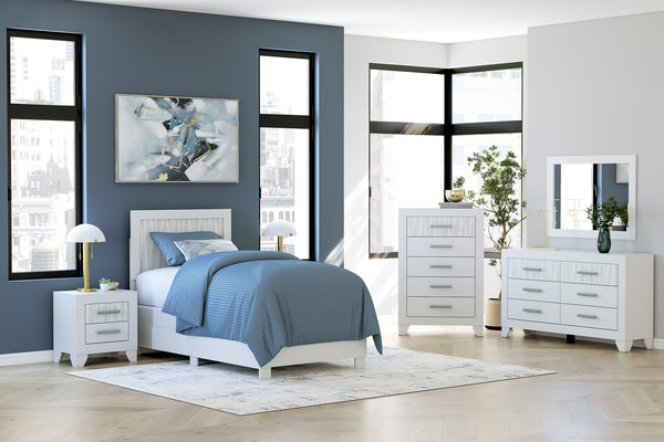 Dormitorio moderno con cama blanca, gavetero con espejo y mesitas de noche sobre una pared azul.