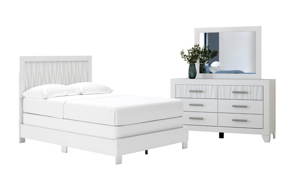 Conjunto de dormitorio blanco con cama y gavetero con espejo sobre fondo blanco.