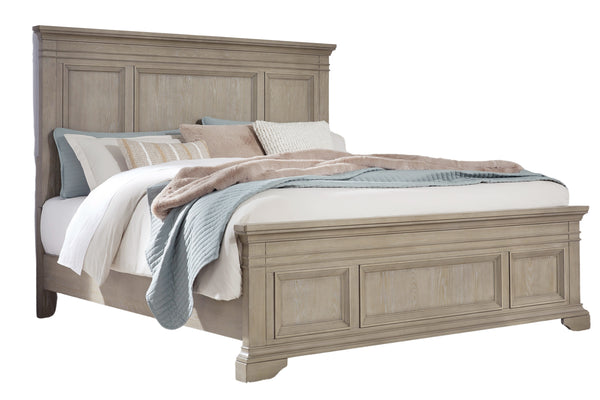 Cama matrimonial de estilo clásico en madera clara con cabecera y pie con paneles decorativos. Está vestida con ropa de cama en tonos neutros, incluyendo cojines y manta, y se muestra sobre fondo blanco.