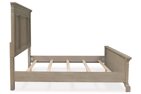 Base de cama de estilo clásico en madera clara con cabecera y pie de cama con paneles decorativos. Incluye estructura visible con soporte de tablillas, presentada sobre fondo blanco en una vista de ángulo lateral. 