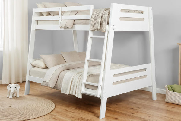 Litera de madera blanca con escalera integrada, decorada con ropa de cama beige y una manta, en una habitación infantil con suelos de madera clara y paredes de tonos neutros.