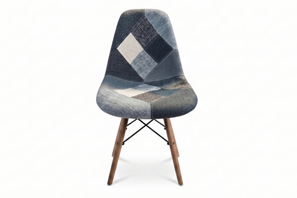 Una moderna silla con asiento y respaldo de tela tipo patchwork en tonos grises, azul marino y blanco, con patas de madera cónicas, sobre un fondo color blanco.