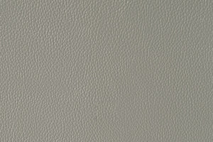 Primer plano de una textura de piel sintética de color gris claro que llena el encuadre.