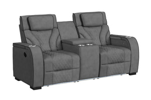 Loveseat reclinable de dos plazas en color gris oscuro, con tapizado acolchado de patrón geométrico, cabeceras ajustables, consola central con portavasos y compartimentos integrados. Diseño moderno con iluminación LED en la base.