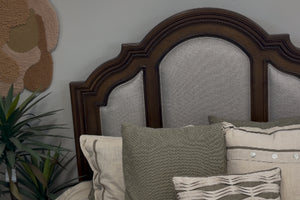 Vista cercana de cabecera de cama hecha de madera y con acolchado blanco. 