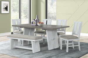 Juego de comedor estilo rústico moderno con mesa rectangular de acabado blanco envejecido, cuatro sillas a juego y banco tapizado. El conjunto combina texturas de madera y tonos neutros para crear un ambiente cálido y acogedor.