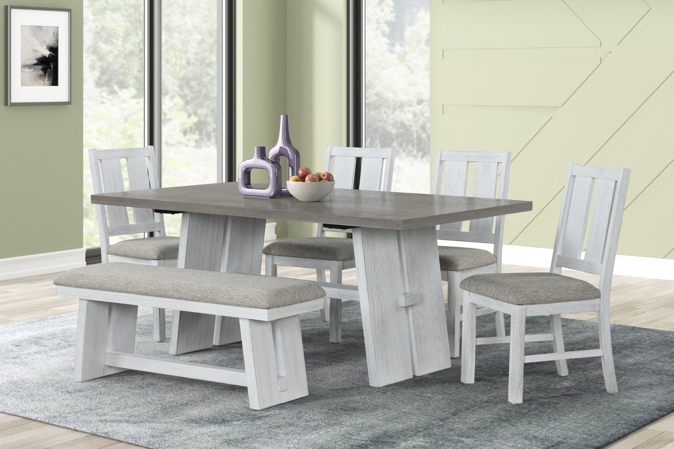 Mesa de comedor blanco y gris con cuatro sillas y un bench en un entorno de comedor verde con ventanas. 