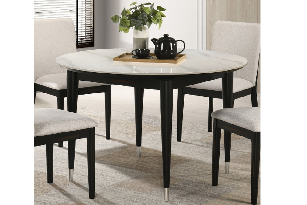 Mesa de comedor redonda con tablero tipo mármol y patas negras sobre fondo blanco.