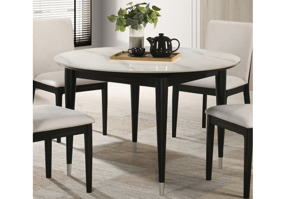 Comedor amueblado con mesa redonda y sillas en una habitación bien iluminada.