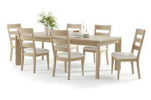 Mesa deslizante con seis sillas con acolchado blanco y objetos decorativos en la mesa en una sala de comedor neutral. 
