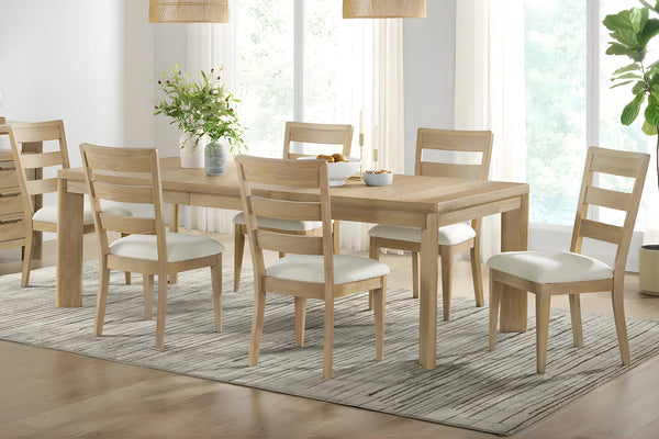 Mesa deslizante con seis sillas con acolchado blanco y objetos decorativos en la mesa en una sala de comedor neutral. 