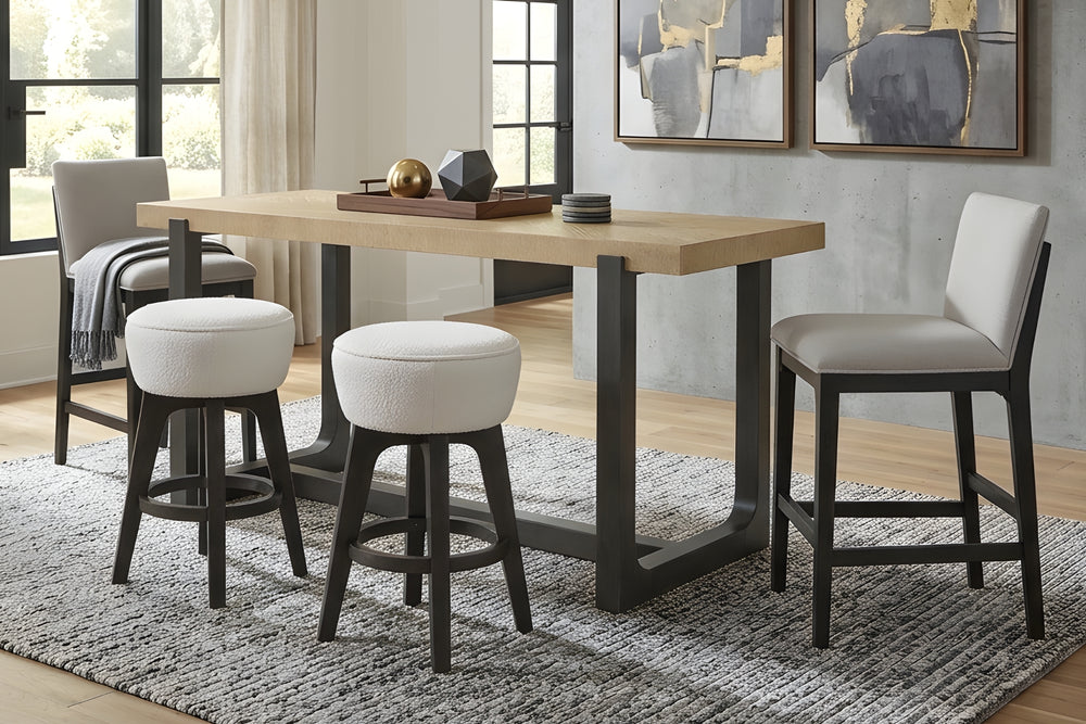 Mesa rectangular tapizada en marco negro con tope marrón claro y dos sillas tapizadas con respaldo y dos taburetes más pequeñas sin respaldo con acolchados grises en fondo blanco. 
