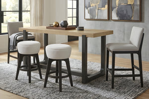 Mesa alta contemporánea de madera clara con base metálica negra, acompañada de dos bancos redondos tapizados en tela blanca y dos sillas altas acolchadas en tono beige, ubicada sobre una alfombra texturizada en un comedor moderno con decoración minimalista.