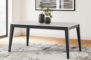 Mesa rectangular en marco negro con tope de diseño de mármol en una sala neutral con objetos decorativos. 