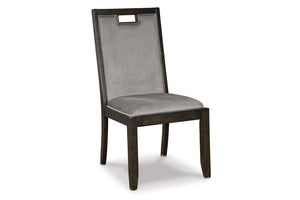 Silla de comedor con asiento y respaldo alto tapizados en tela gris, estructura y patas de madera oscura y abertura rectangular en la parte superior del respaldo.