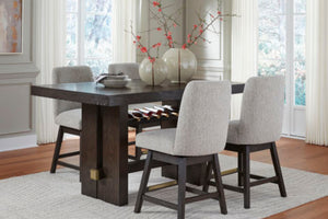 Mesa rectangular marrón oscuro con cuatro taburetes con acolchado gris claro en marco marrón oscuro en sala de comedor con ventanas. 