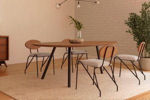 Juego de comedor moderno con mesa rectangular de madera de bordes redondeados y cuatro sillas con respaldo de madera, asientos tapizados en gris claro y estructura metálica negra. Ambientado en un espacio contemporáneo con decoración minimalista y tonos cálidos.