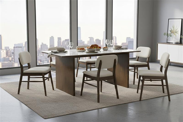 Mesa de comedor puesta con seis sillas en una habitación moderna con grandes ventanales que dan a un paisaje urbano.