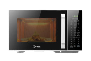 Microondas Midea color plateado y negro con puerta de vidrio, panel digital táctil al lado derecho y alimento calentándose en el interior sobre un plato giratorio.