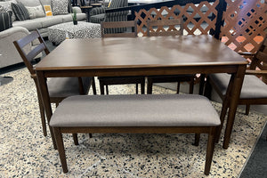 Juego de comedor de madera en acabado café oscuro con mesa rectangular, cuatro sillas de respaldo horizontal y banco tapizado en gris. Diseño funcional y acogedor, ideal para comedores familiares y espacios de estilo contemporáneo.
