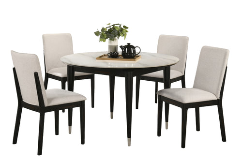 Juego de comedor de 5 piezas que incluye una mesa redonda con tablero de mármol blanco y patas negras, y cuatro sillas a juego de respaldo alto con asientos tapizados en beige claro y estructura negra; se muestra sobre un fondo blanco.