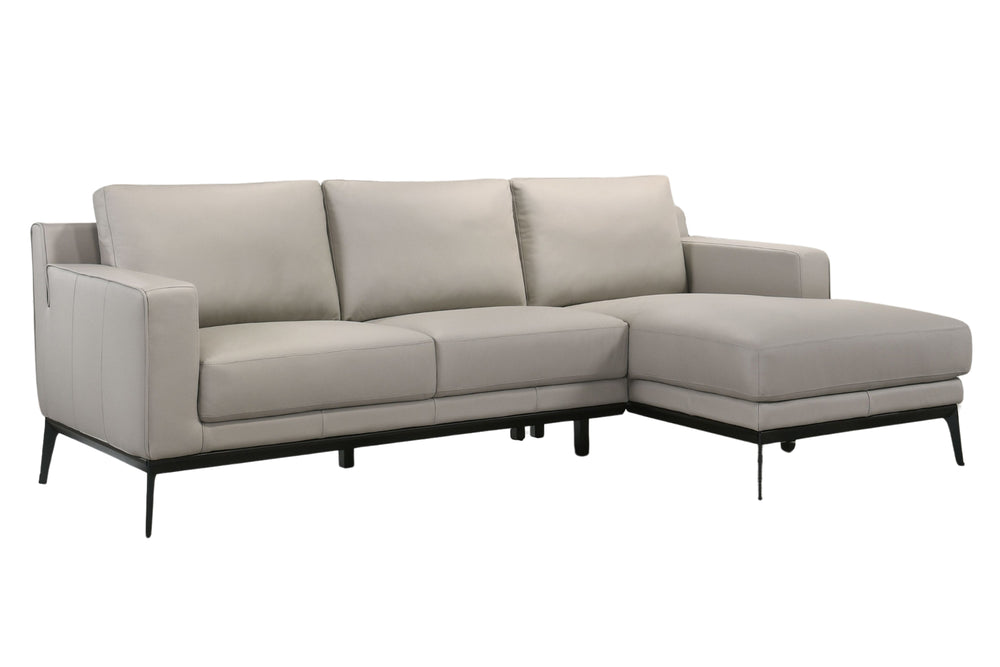 Sofá chaise de color gris claro con patas acabadas en negro sobre un fondo blanco. 