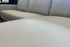 Primer plano de un sofá gris claro con fondo desenfocado. 