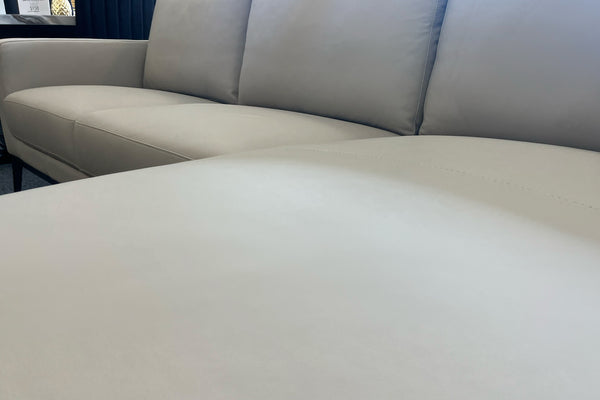 Primer plano de un sofá gris claro con fondo desenfocado. 