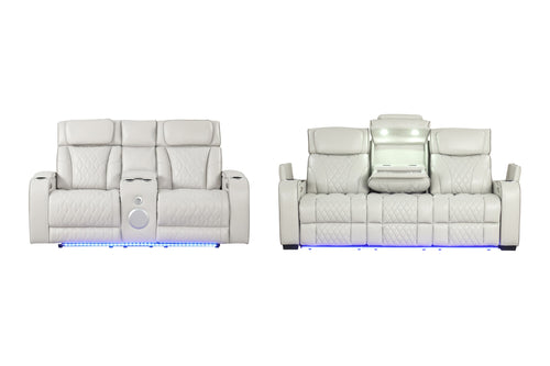 Sofá reclinable de cuero blanco para sala de cine, mostrado de frente y de espaldas sobre un fondo blanco, que cuenta con iluminación LED azul en la base y una consola central con altavoz y compartimento de almacenamiento iluminado.