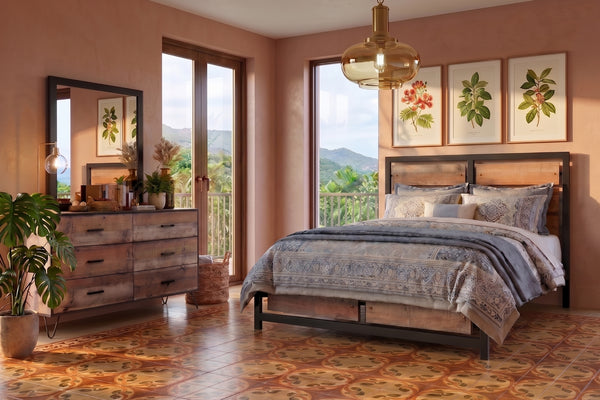 Juego de Habitación moderno con cama de madera y estructura metálica negra, ropa de cama en tonos beige y gris con patrones decorativos, gavetero de madera rústica, lámpara colgante de vidrio ámbar y grandes ventanas con vista a un paisaje tropical.