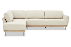 Sofá chaise de color beige con patas acabadas en madera marrón claro sobre un fondo blanco. 