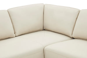 Vista cercana de sofá chaise de color beige sobre un fondo blanco. 