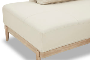 Sofá chaise beige con patas de madera sobre fondo blanco.