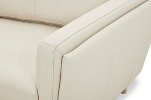 Primer plano de un sofá chaise beige con detalles de costura visibles.