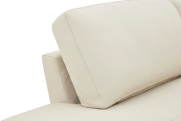 Primer plano de un sofá chaise beige con fondo blanco.