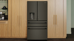 Una nevera estilo puerta francesa de color gris oscuro con un cajón congelador inferior, ubicada entre gabinetes de cocina de madera clara.