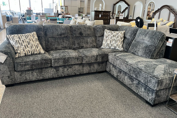 Sofá modular gris con cojines estampados en una sala de exposición