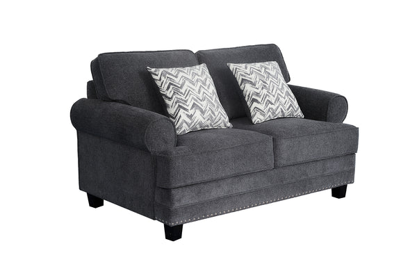 Loveseat tapizado en tela gris oscuro con brazos redondeados, cojines decorativos con patrón en zigzag gris y blanco, detalles de tachuelas metálicas en la base y patas negras de madera.