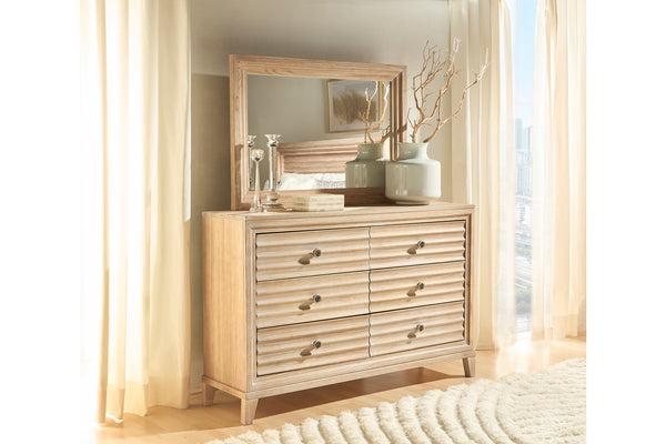 Gavetero de madera con espejo en una habitación con cortinas y decoración.