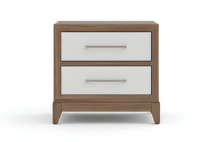 Mesita de noche de madera con dos gavetas blancas, lámpara y objetos decorativos en un dormitorio.