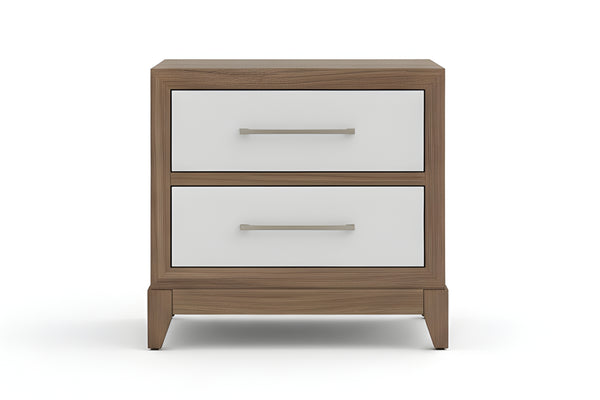 Mesita de noche de madera con dos gavetas blancas, lámpara y objetos decorativos en un dormitorio.