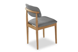 Silla con asiento y respaldo acolchados en gris sobre fondo blanco.