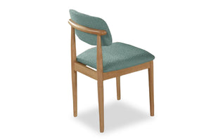 Silla con asiento y respaldo acolchados en verde sobre fondo blanco.