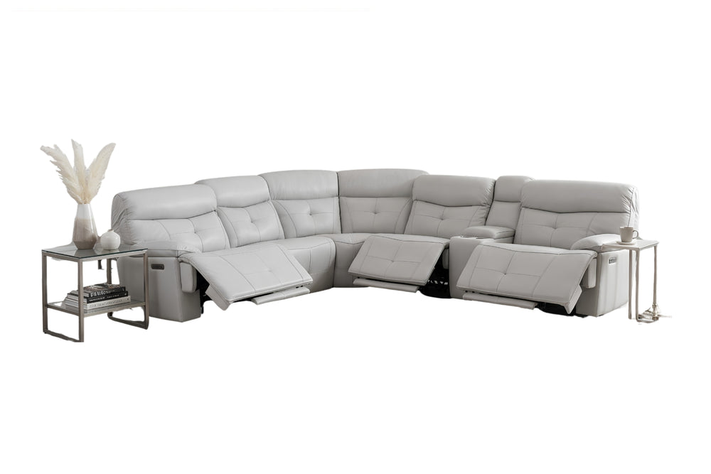 Un gran sofá modular de color gris claro con múltiples asientos reclinables y reposapiés extensibles, mostrado unas mesas auxiliares y una planta en maceta.