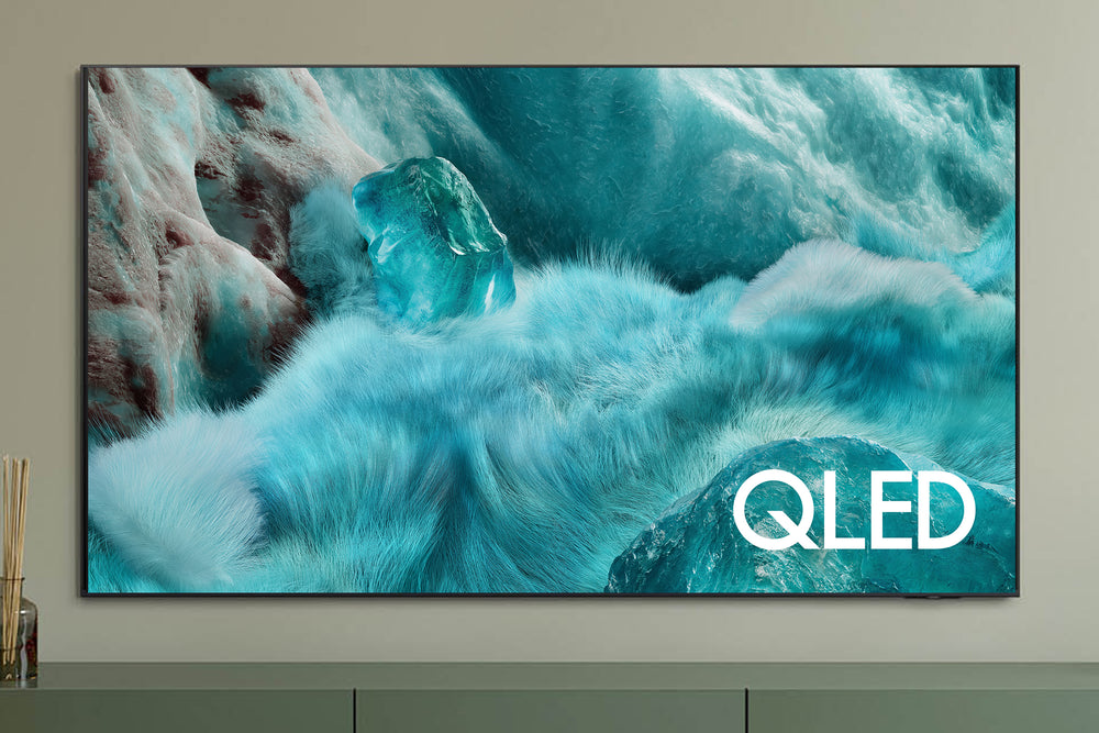 Televisor QLED que muestra una escena de la naturaleza con rocas y agua, con el logotipo QLED.