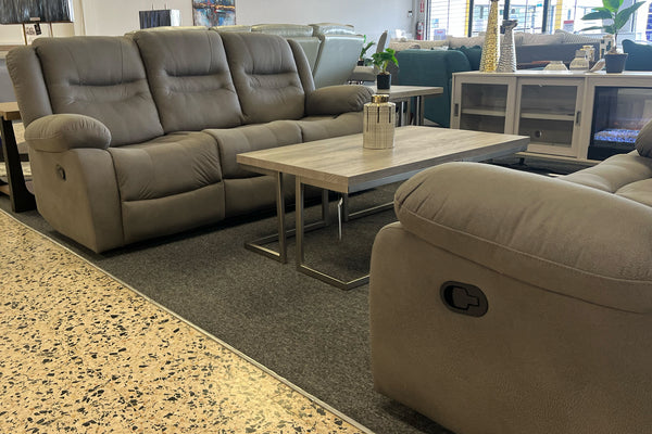 Sofá y loveseat reclinables en color gris con asientos acolchados y respaldos mullidos, acompañados de una mesa de centro rectangular con acabado de madera clara en una sala de exhibición de muebles.