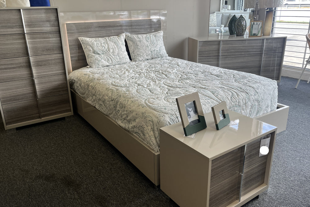 Conjunto de dormitorio gris claro con cama con luces LED integradas, gavetero con espejo, chest y mesita de noche en una ambientación de habitación.
